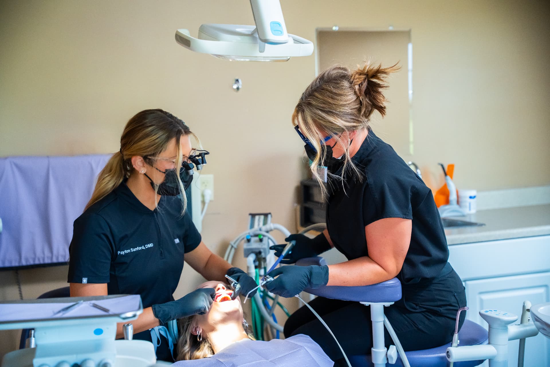 Dr. Payton Sanford and an assistant treating a patient